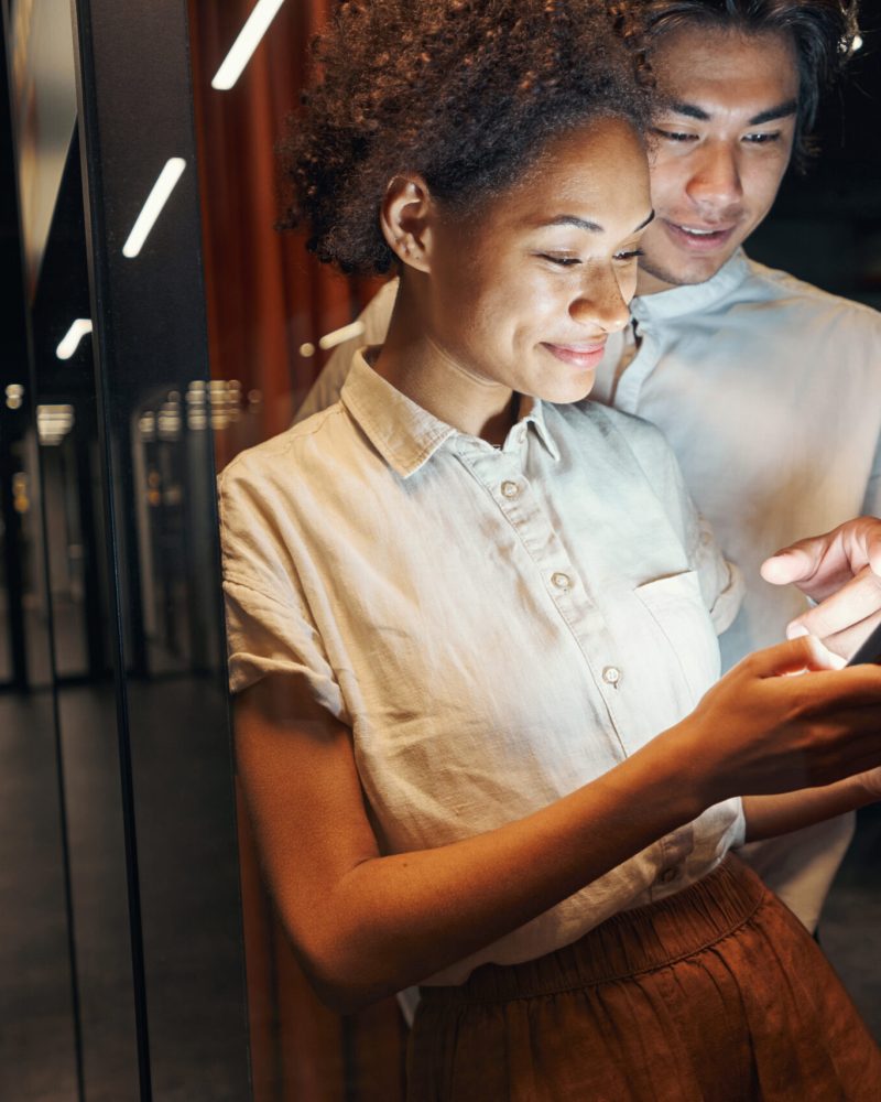 Female person looking at display of smartphone and filling in data of credit card
